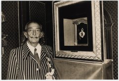 Fotografia en blanc i negre de Salvador Dalí junt a una de les seves obres que formen la col•lecció de joies de l'artista.